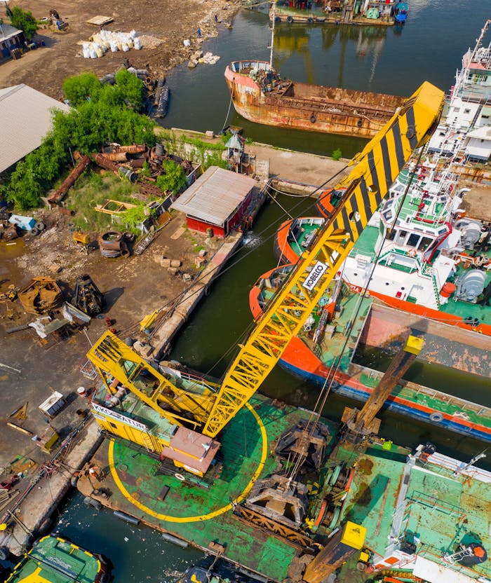 Aerial view of a bustling industrial dock with cranes and ships in Jakarta, Indonesia.